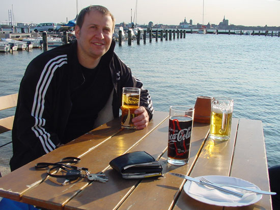 Jan im Hafen sitzend bei strahlendem Sonnenschein nach einem erfolgreichen Angeltag