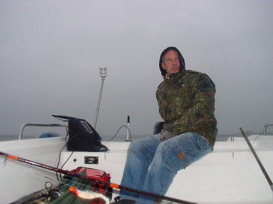 Angler Thomas bei starken Regnschauer, arbeitend mit dem Echolot
